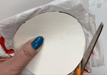 scissors cutting plastic bag around cardboard circle