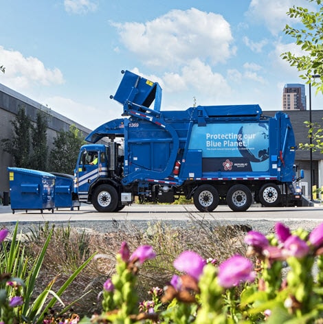 Trash truck emptying dumpster