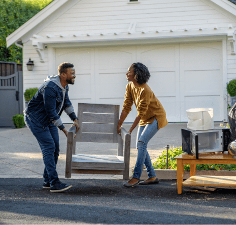 Couple disposing of chair bulk waste