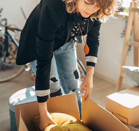 Woman packing pillow in box
