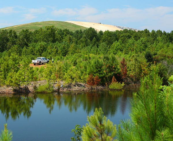 Landscape with truck, lake, and landfill