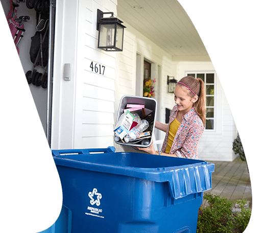 Child emptying recycling bin into recycling container