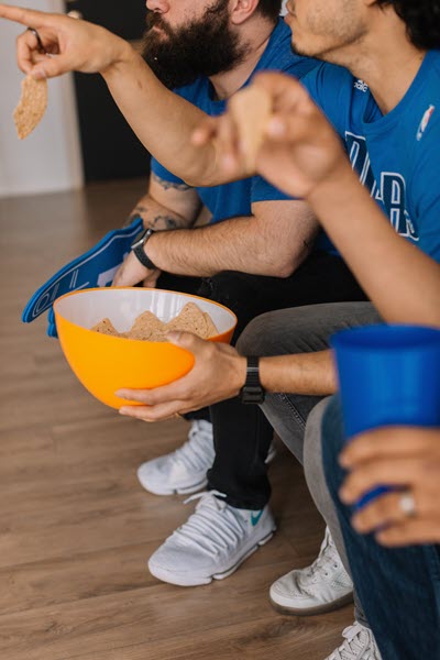 men eating snacks and watching the game