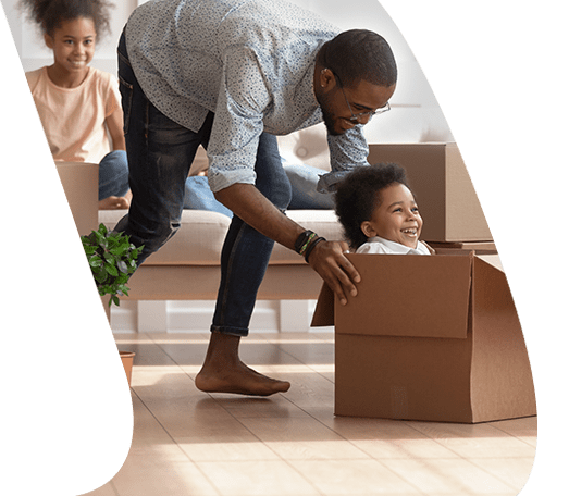 Kid sitting in moving box smiling with parents nearby