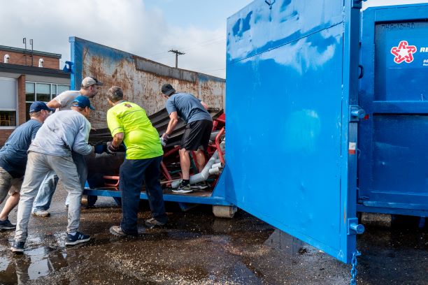 workers loading a dumpster