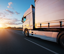transport truck driving into sunrise