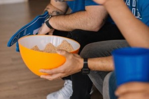men eating snacks and watching the game