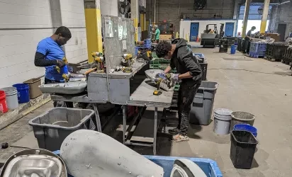 people doing hands-on learning in a recycling facitlity