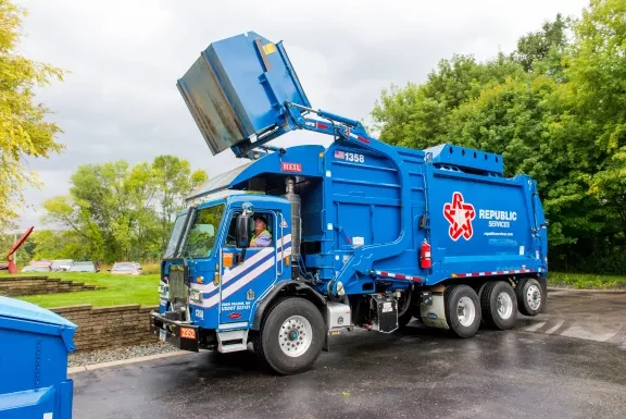 Garbage truck lifting dumpster