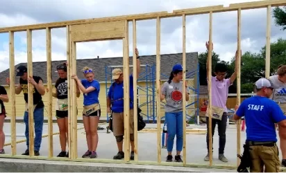 people putting up framing of a house